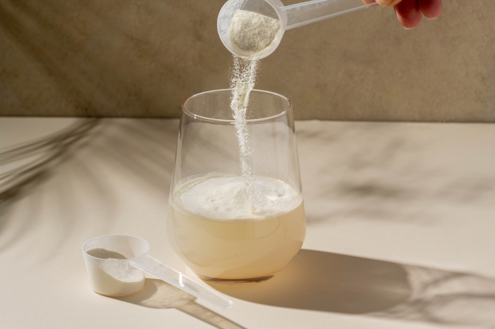 Measured scoop of powder dosed into a glass of water, a typical gum acacia application