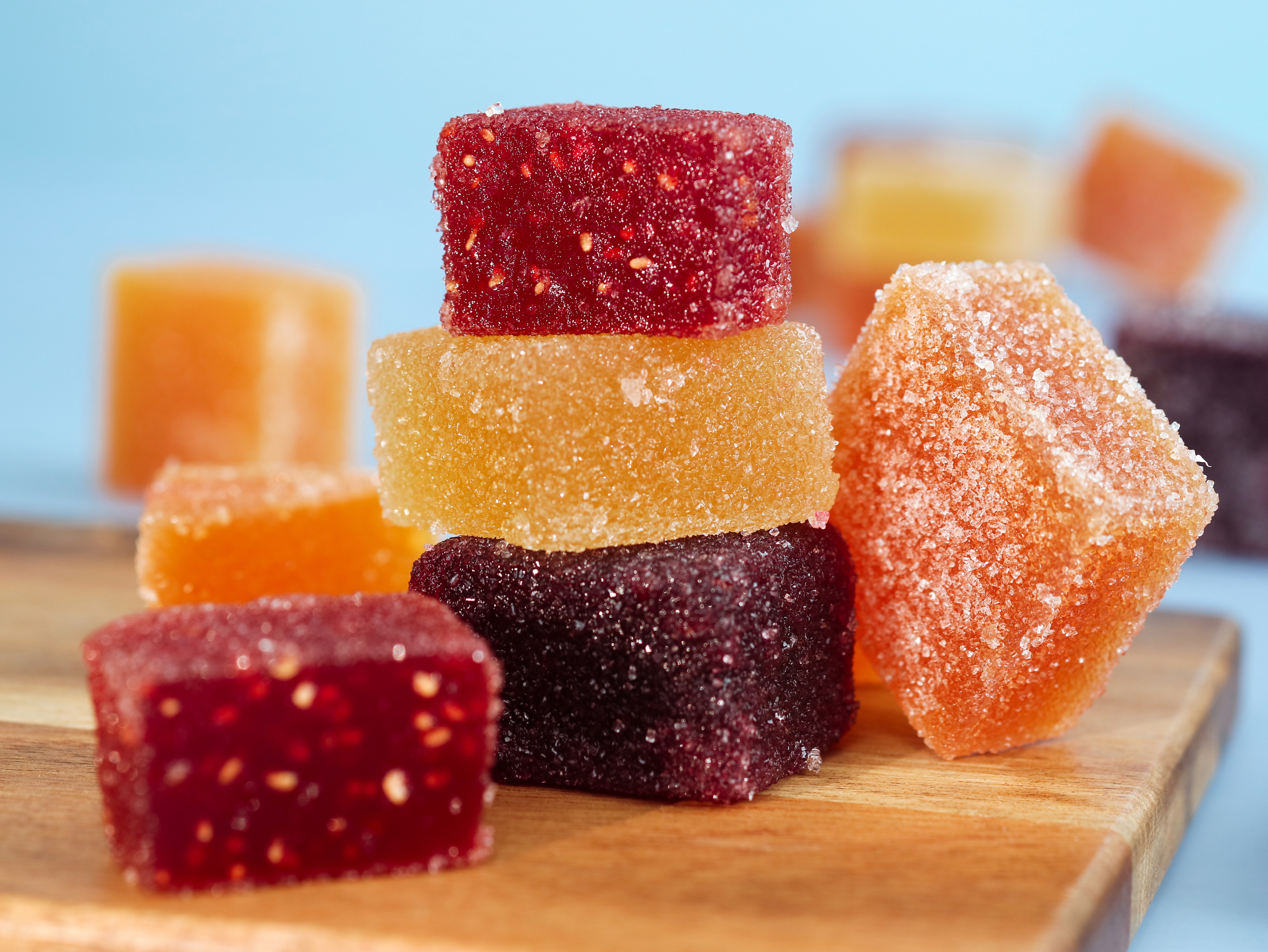 Sugar-coated pectin gummies on a wooden surface, the format used for most fast-onset cannabis edibles