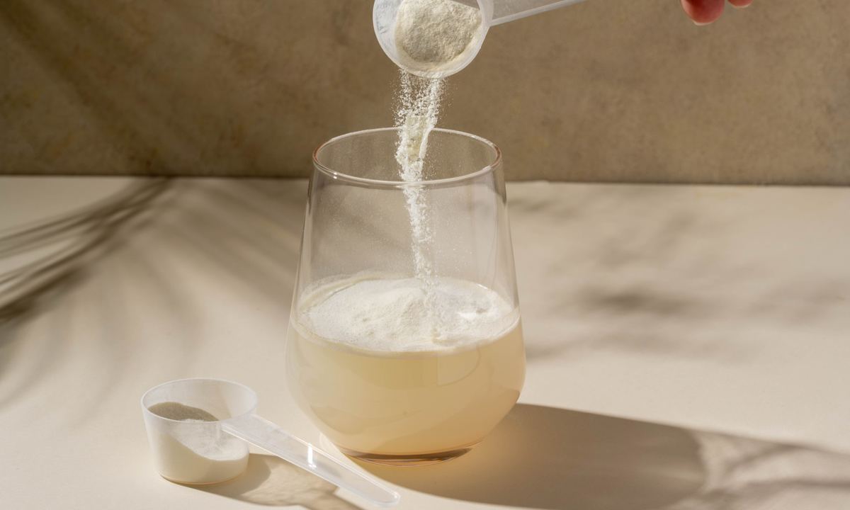 Spray-dried gum acacia powder poured into a glass of water